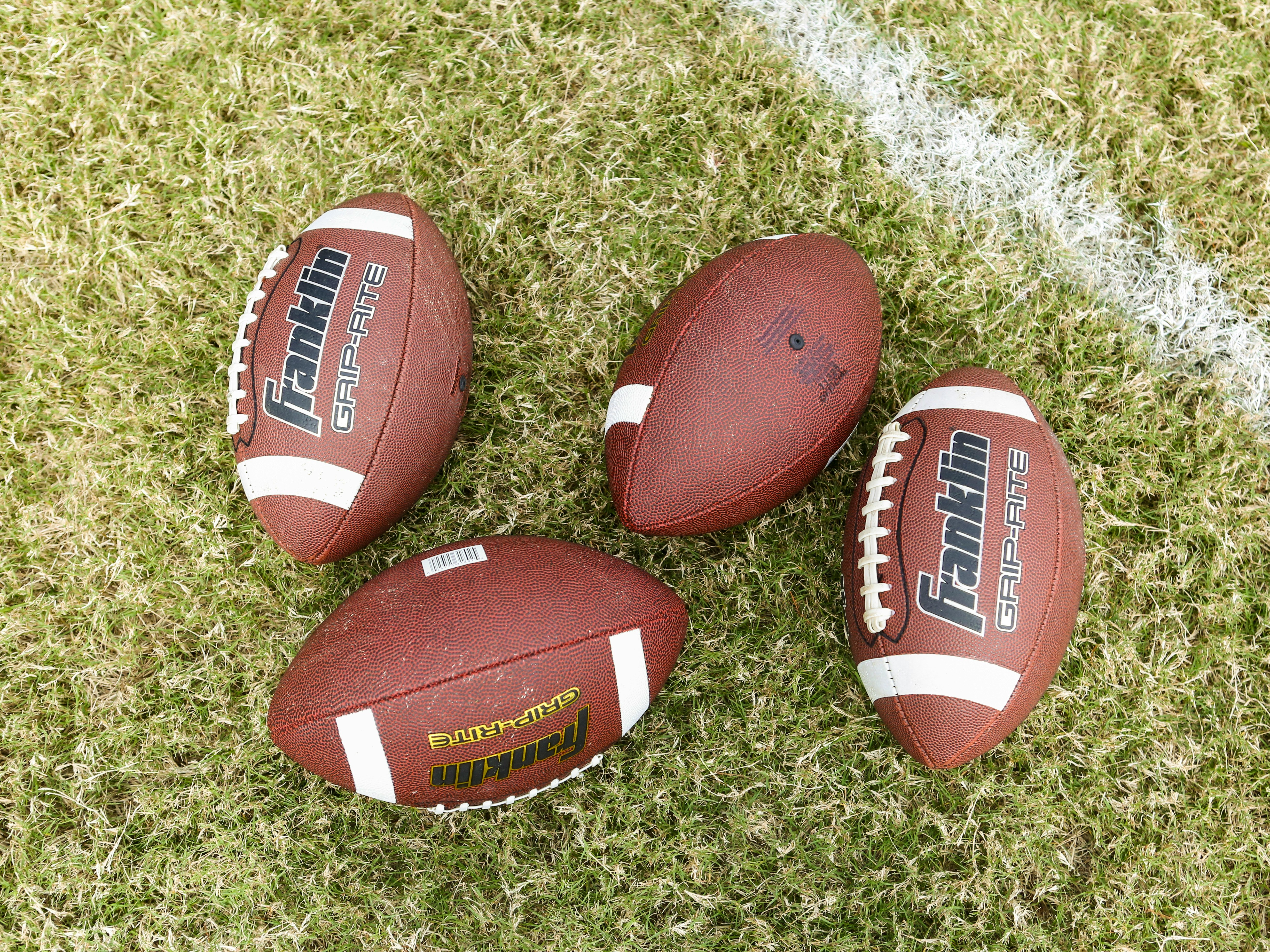 red and white football on green grass